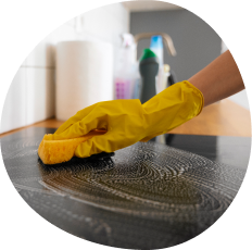 Main gantée nettoyant une surface lors d’un service d’entretien du logement dans le Jura